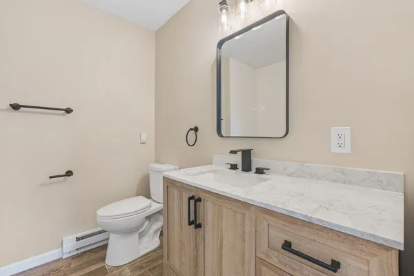 a bathroom with a toilet sink and mirror