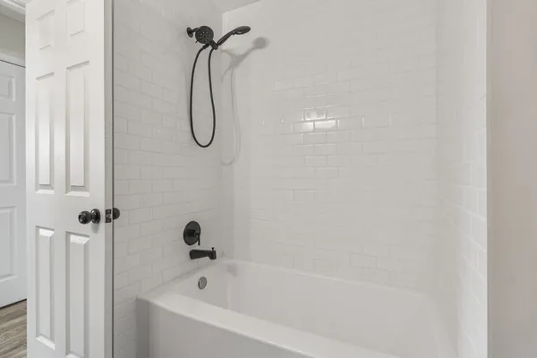 a bathroom with a bath tub with a shower