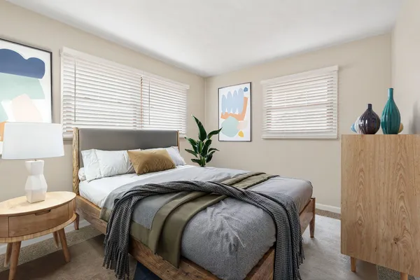 a bed sitting in a bedroom next to a window