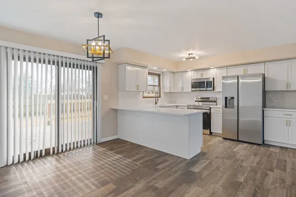 a kitchen with stainless steel appliances a refrigerator sink and microwave