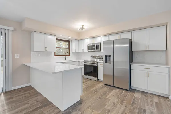 a kitchen with granite countertop a refrigerator stove top oven and sink