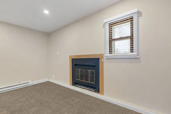 an empty room with a fireplace and window