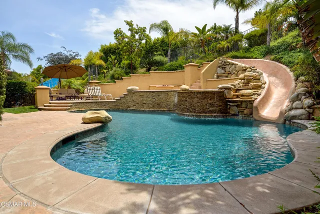 a view of a swimming pool with a yard and plants