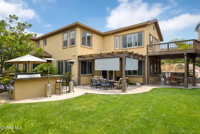 a front view of a house with garden and sitting area