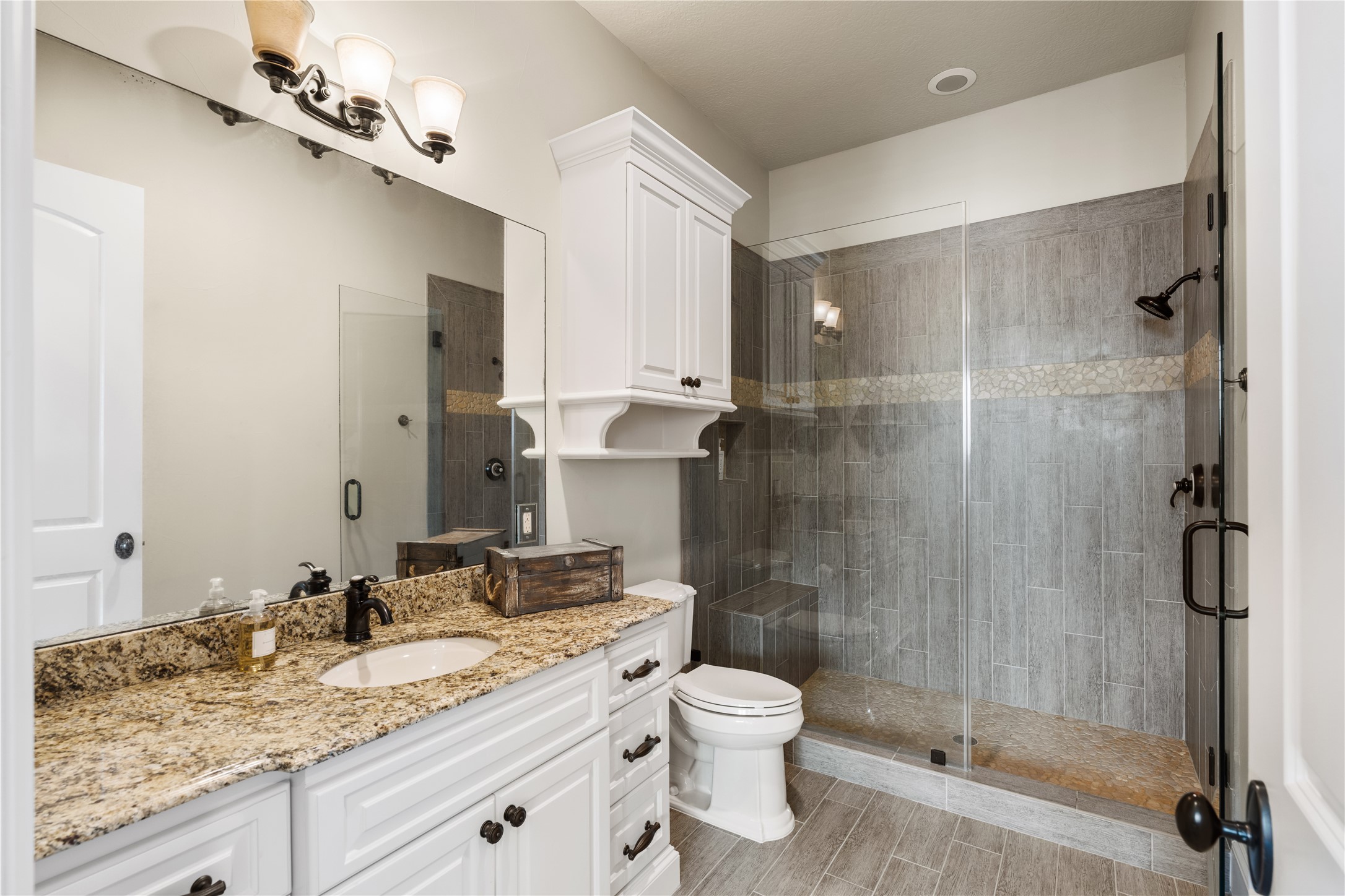 12349 Longmire Trace Conroe, TX 77304 - Photo 26 of 48 Granite vanity, ample cabinetry, and a frameless glass walk-in shower for spa-like mornings.