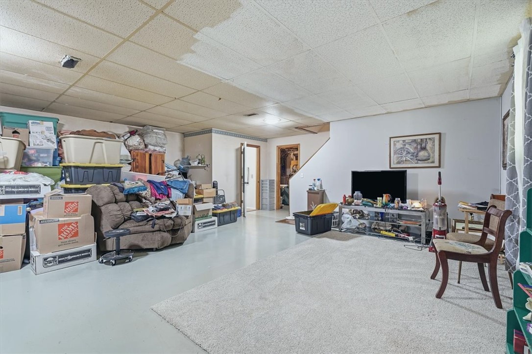 211 Cedar Ridge Drive Westminster, SC 29693 - Photo 21 of 34 An expansive basement living area features drop-ceiling tiles and concrete flooring.
