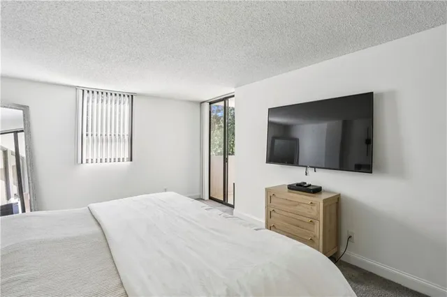 a bedroom with a bed and a flat screen tv