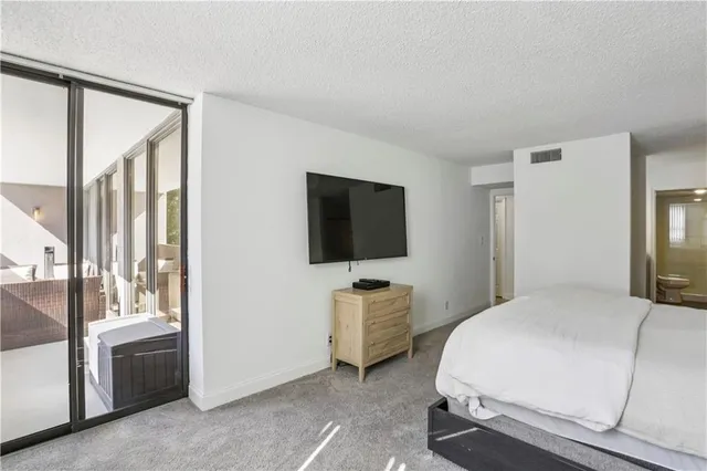 a bedroom with a bed and large flat screen tv