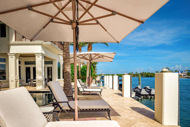 620 Golden Harbour Drive Boca Raton, FL 33432 - Photo 42 of 45 a view of a patio with table and chairs under an umbrella