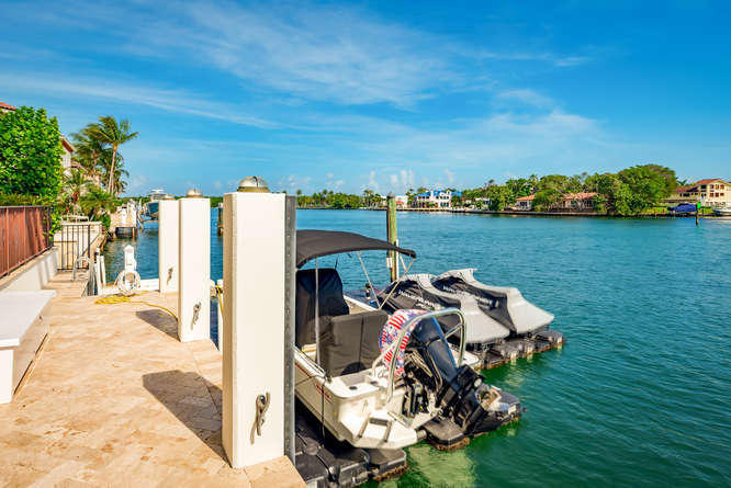 620 Golden Harbour Drive Boca Raton, FL 33432 - Photo 43 of 45 a view of a lake with lawn chairs