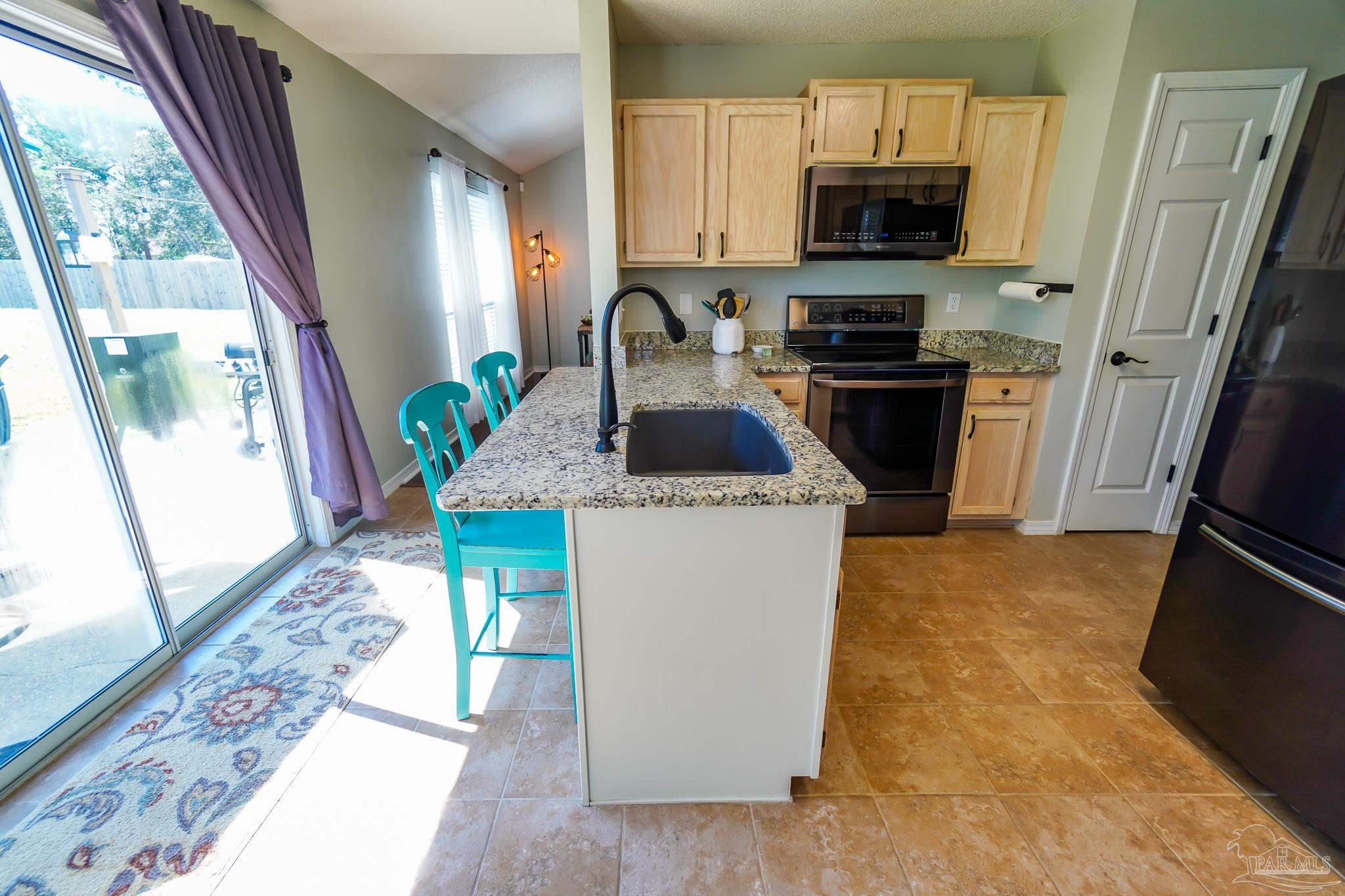 6545 Fern Street Navarre, FL 32566 - Photo 11 of 32 a kitchen with a sink a stove a refrigerator and a window