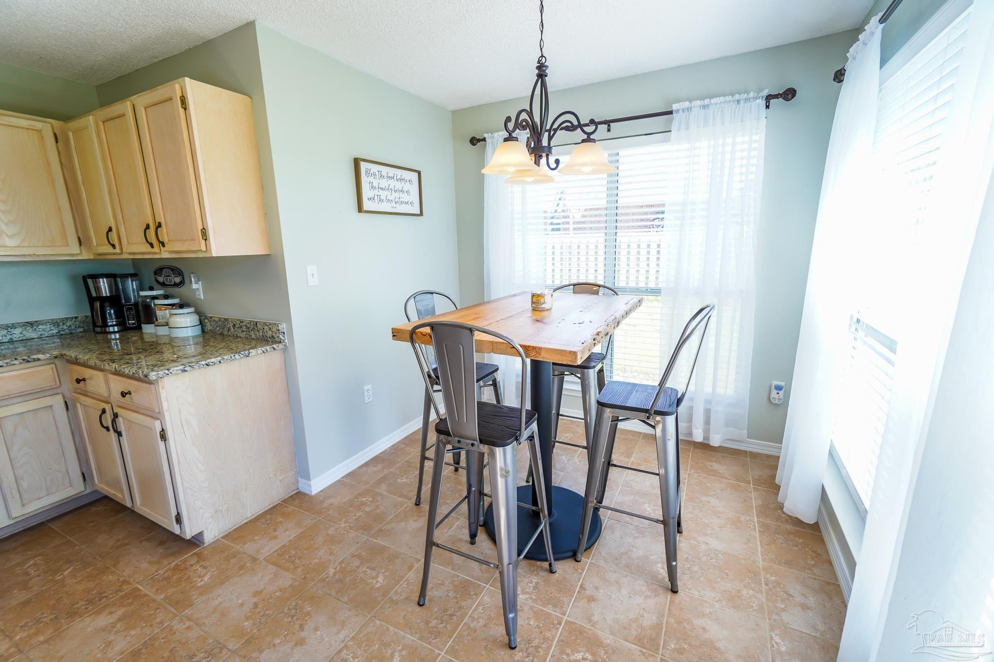 6545 Fern Street Navarre, FL 32566 - Photo 13 of 32 a view of a dining room with furniture and chandelier