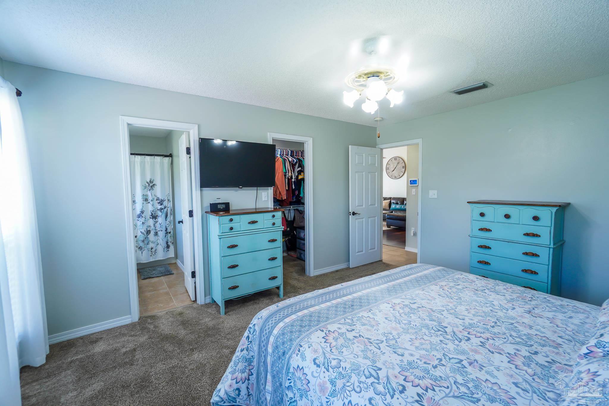 6545 Fern Street Navarre, FL 32566 - Photo 17 of 32 a bedroom with a bed and a mirror