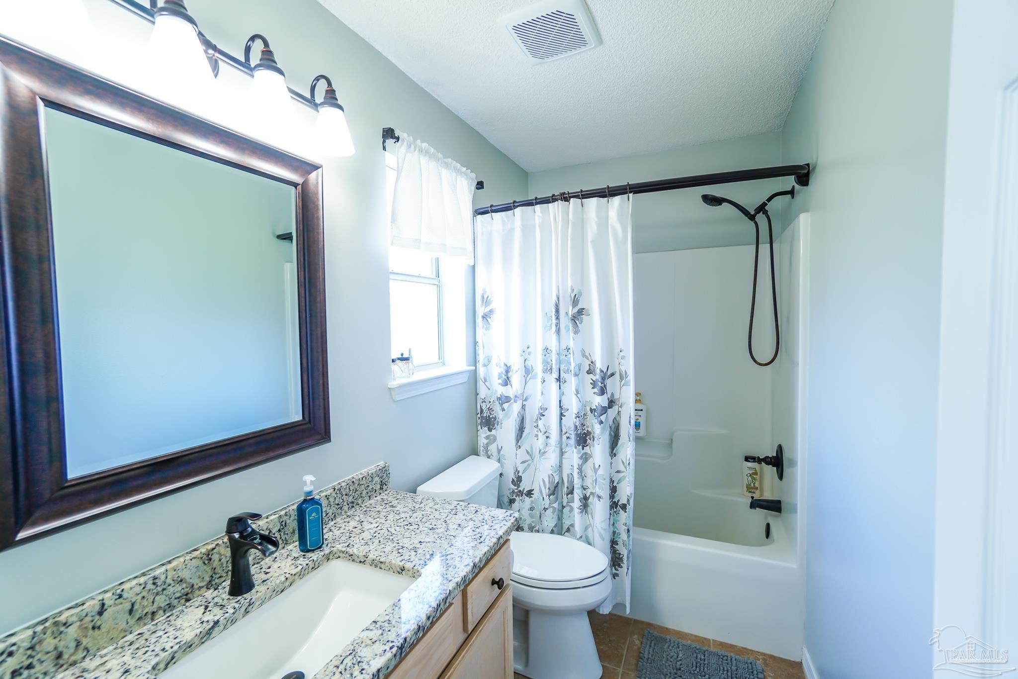 6545 Fern Street Navarre, FL 32566 - Photo 18 of 32 a bathroom with a granite countertop sink toilet and shower