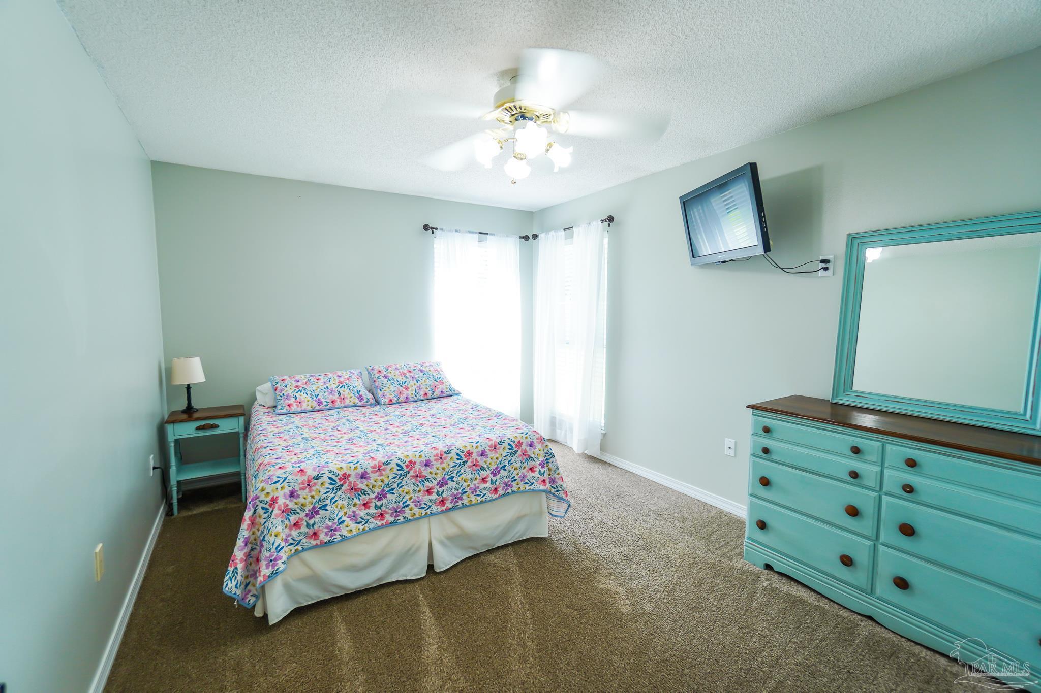 6545 Fern Street Navarre, FL 32566 - Photo 20 of 32 a bedroom with a bed and a chandelier