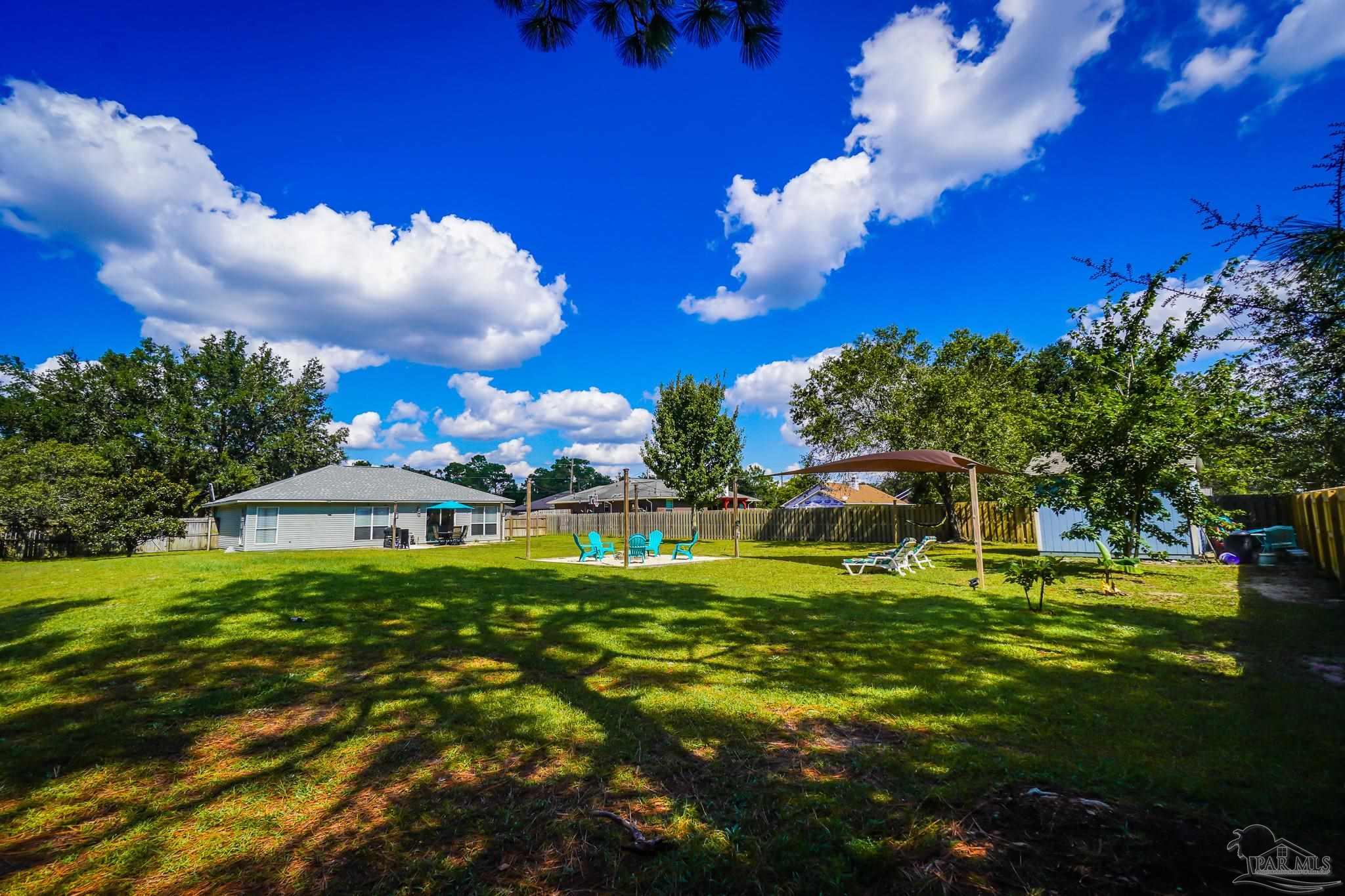 6545 Fern Street Navarre, FL 32566 - Photo 29 of 32 a view of a house with a big yard