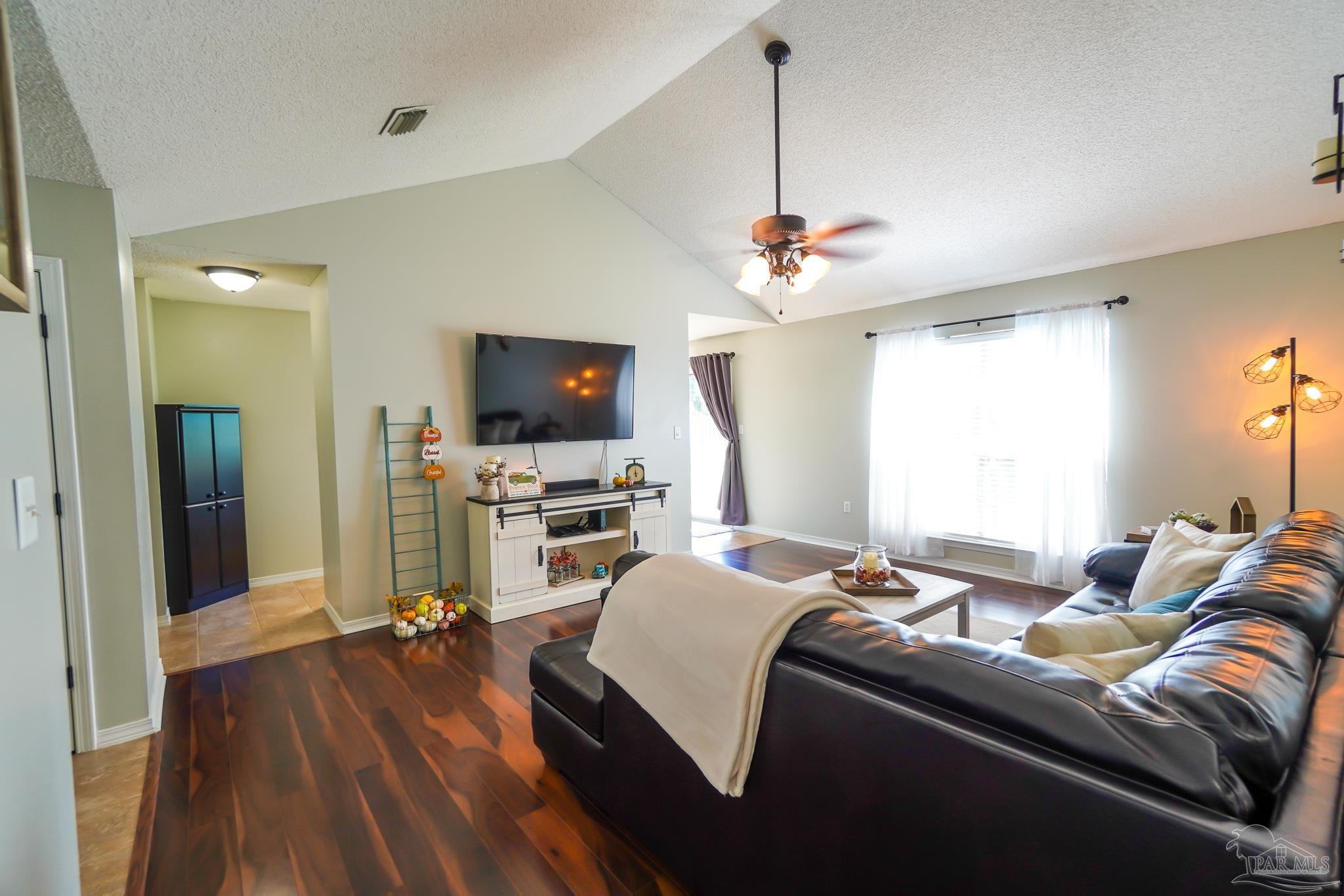 6545 Fern Street Navarre, FL 32566 - Photo 5 of 32 a living room with furniture and a flat screen tv