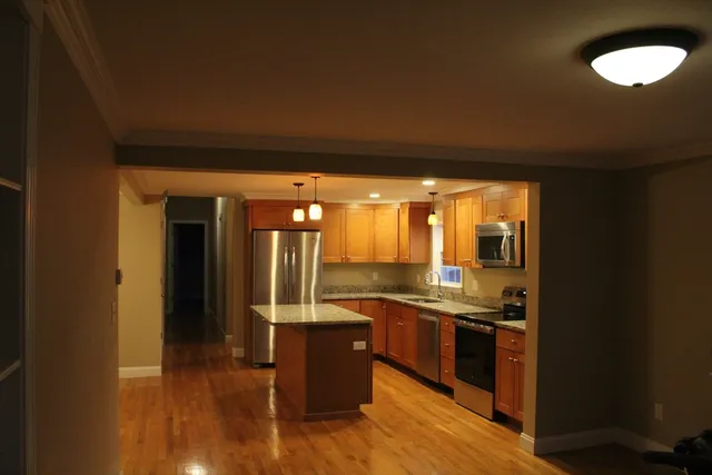 a kitchen with stainless steel appliances granite countertop a sink and wooden cabinets