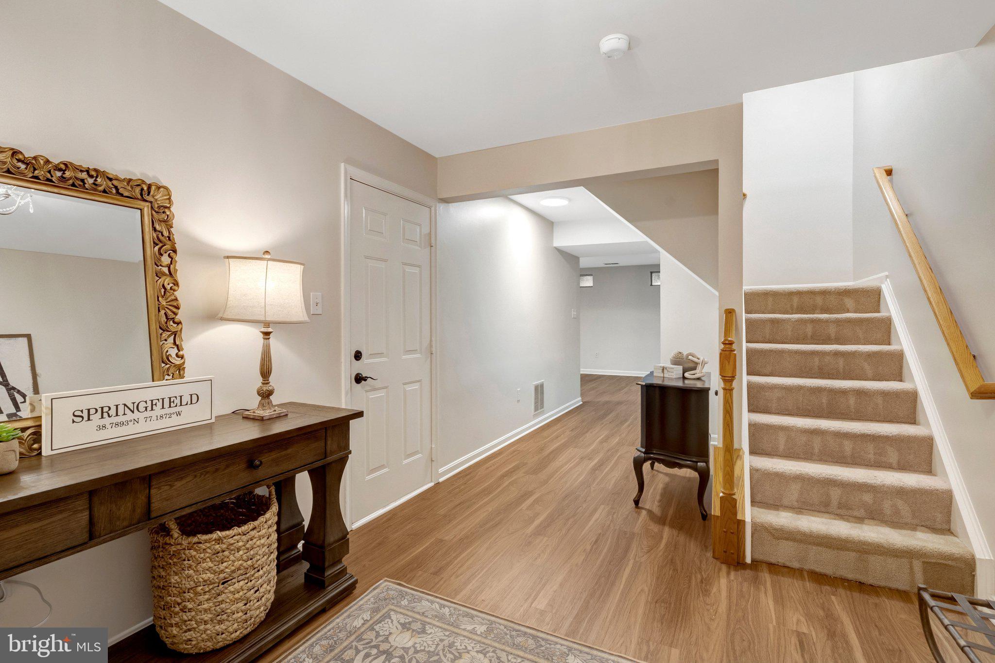 7706 Shadowcreek Terrace Springfield, VA 22153 - Photo 24 of 30 a view of a hallway to a livingroom with wooden floor and furniture