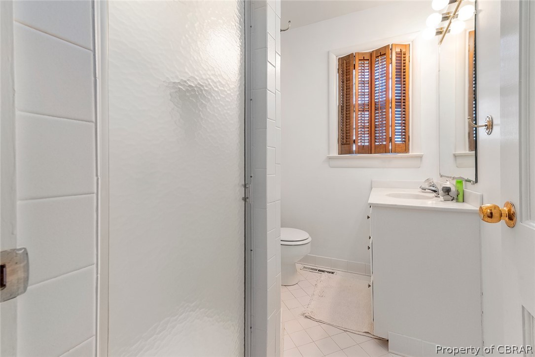 541 Cove Colony Road Lancaster, VA 22503 - Photo 21 of 38 a bathroom with a granite countertop toilet a sink and a mirror
