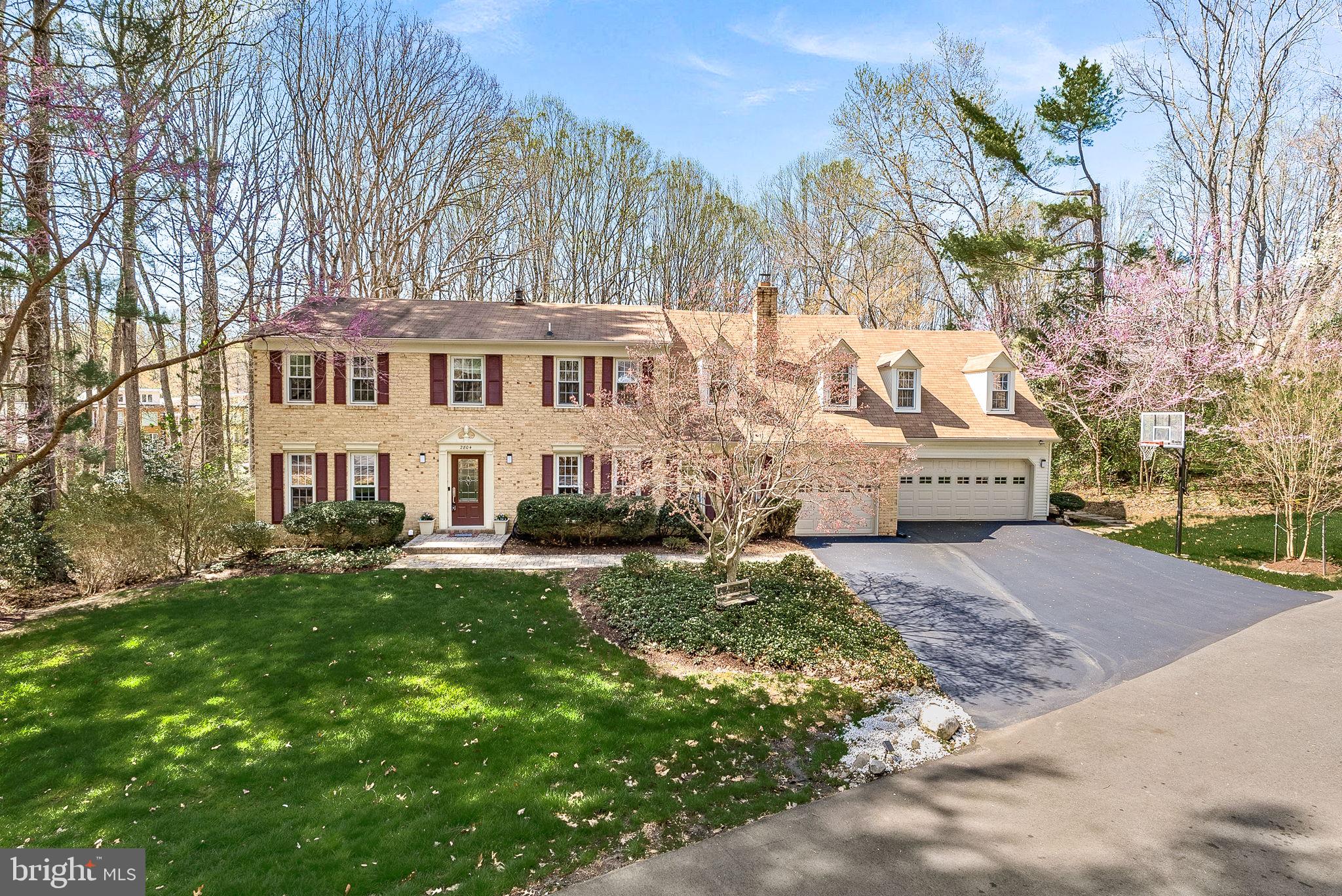 a front view of a house with a yard and lake view