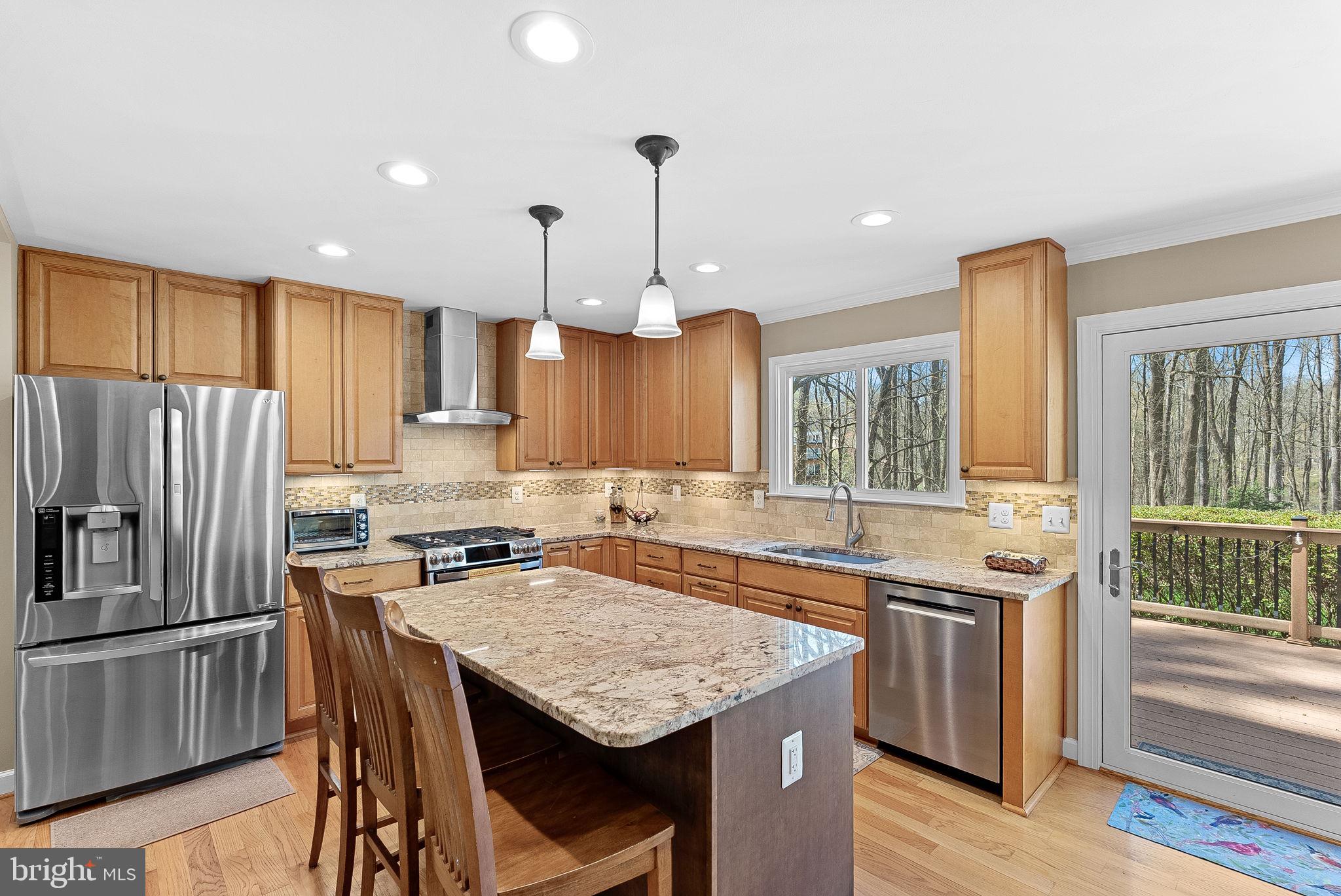 2804 Bree Hill Road Oakton, VA 22124 - Photo 12 of 46 a kitchen with granite countertop a stove a sink dishwasher a refrigerator and wooden cabinets with wooden floor