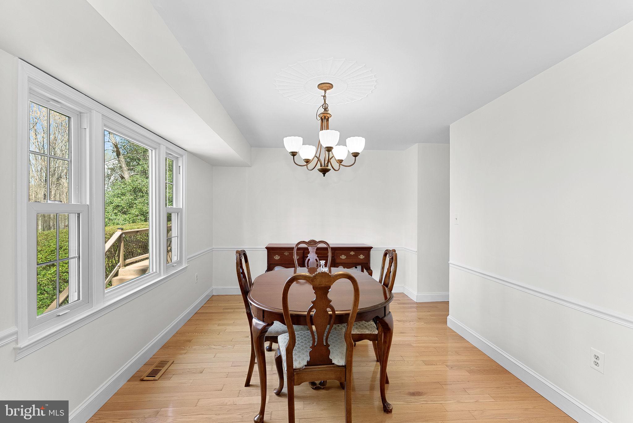2804 Bree Hill Road Oakton, VA 22124 - Photo 17 of 46 a view of a dining room with furniture a chandelier and wooden floor