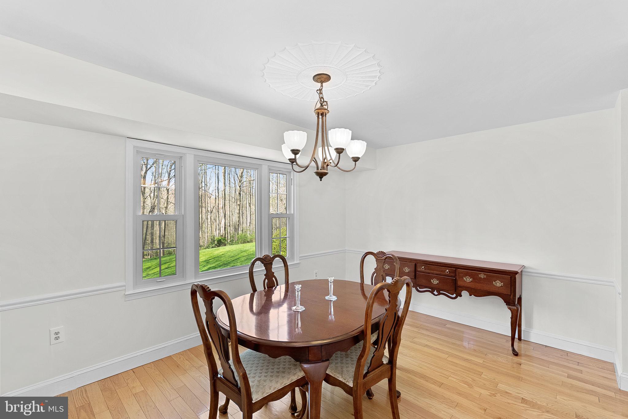 2804 Bree Hill Road Oakton, VA 22124 - Photo 18 of 46 a view of a dining room with furniture a chandelier and wooden floor