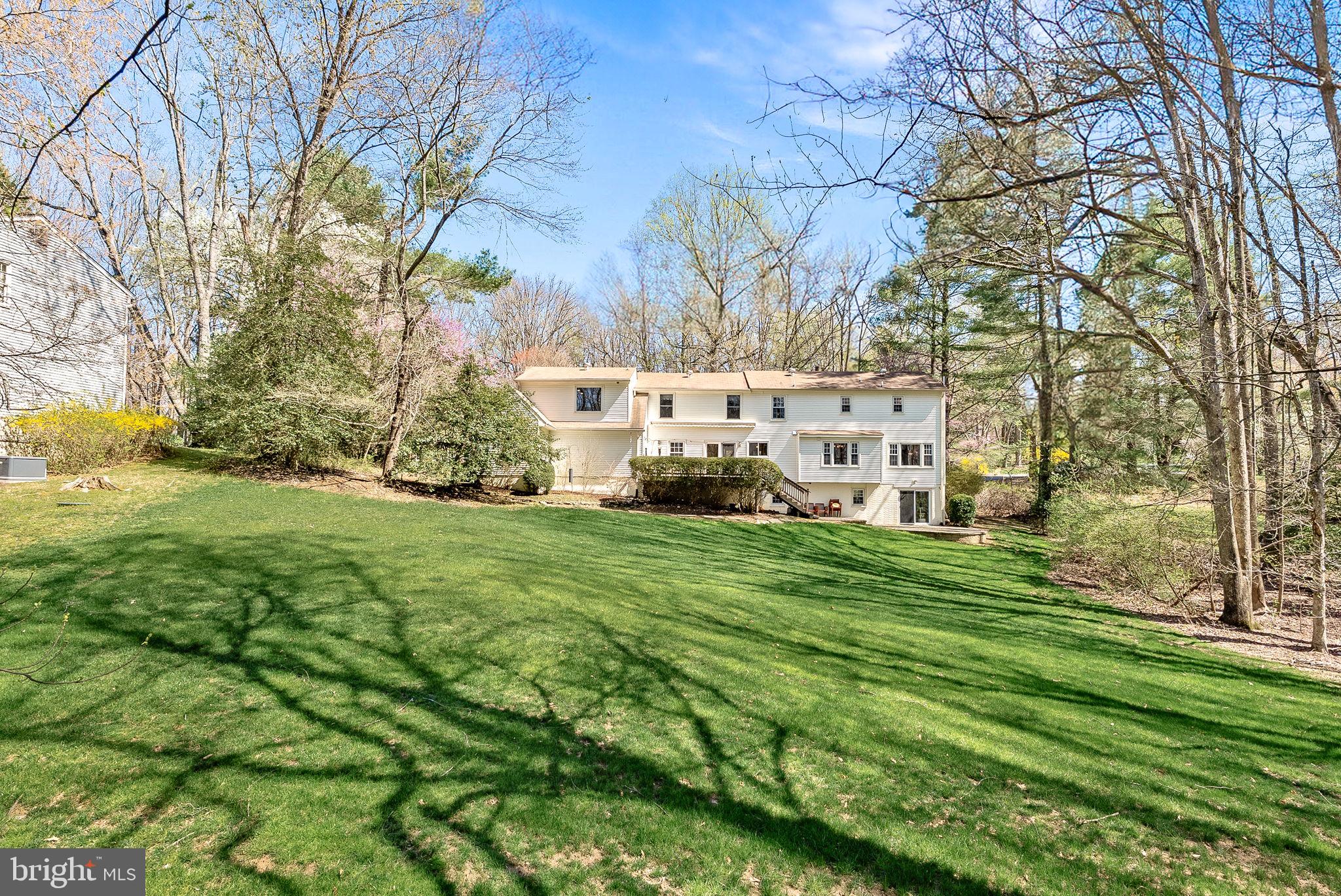 2804 Bree Hill Road Oakton, VA 22124 - Photo 5 of 46 a view of a white house with a big yard and large trees