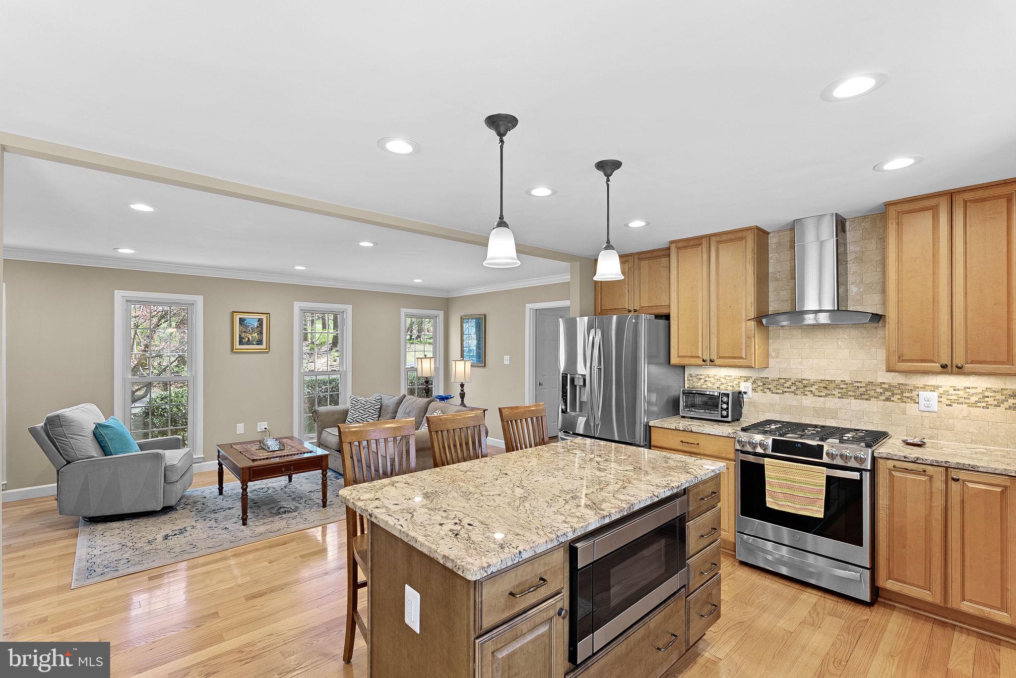 2804 Bree Hill Road Oakton, VA 22124 - Photo 9 of 46 a kitchen with stainless steel appliances granite countertop a stove top oven a sink dishwasher a dining table and chairs with wooden floor