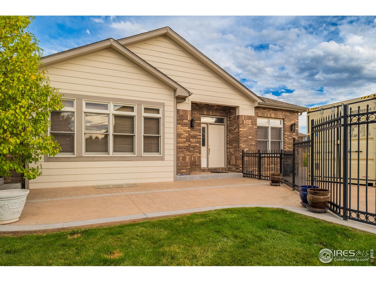 4313 29th Street Road Greeley, CO 80634 - Photo 3 of 31 Welcoming front approach with brick accents and a secure gated courtyard-an elegant first impression.
