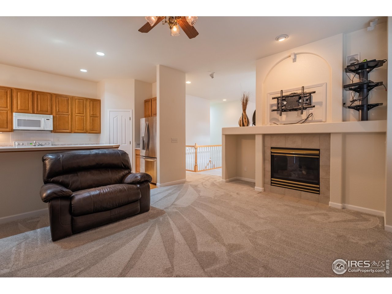 4313 29th Street Road Greeley, CO 80634 - Photo 7 of 31 Inviting living room anchored by a gas fireplace, brand-new carpet, and a stylish display niche.