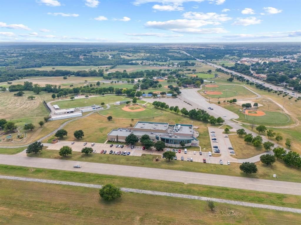 1205 Augusta Road Benbrook, TX 76126 - Photo 21 of 21 Expansive recreational facility featuring multiple baseball diamonds, a contemporary multi-story building, dedicated parking areas, and surrounding green spaces