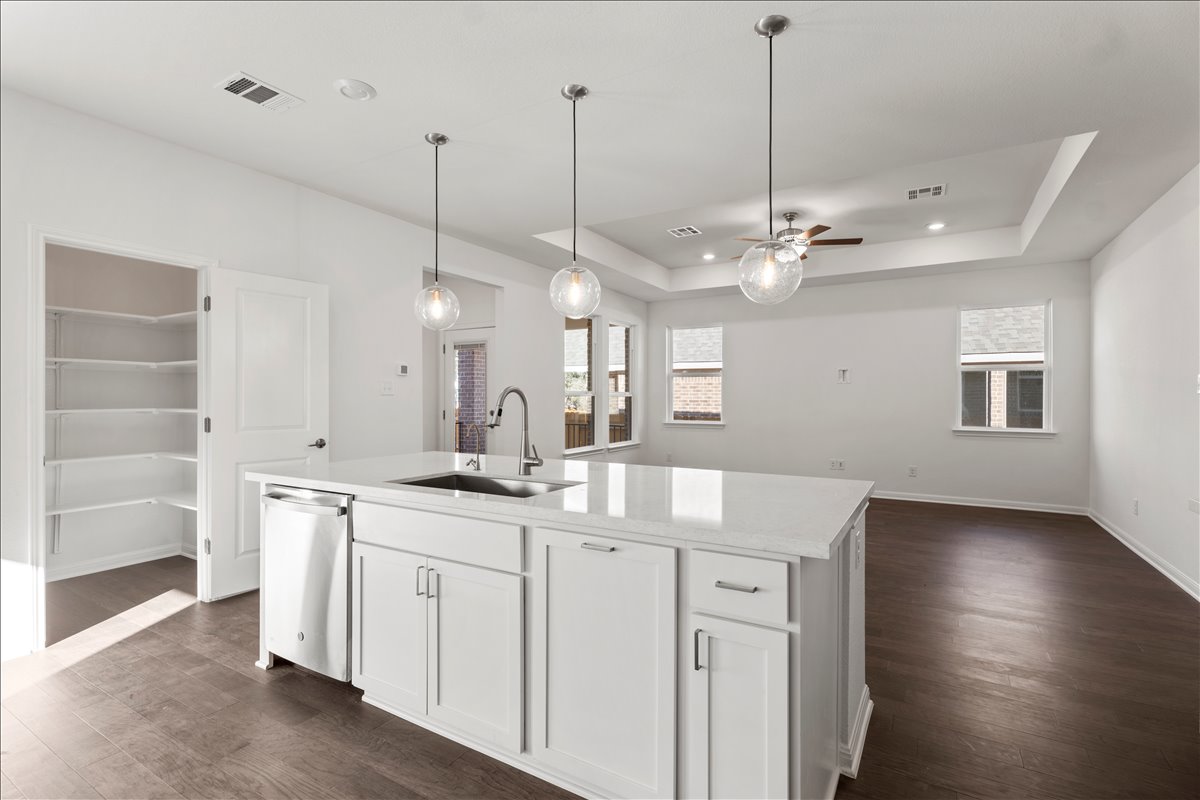 133 Grn Knl Lane Georgetown, TX 78628 - Photo 13 of 31 a open kitchen with a sink dishwasher and a fireplace with wooden floor