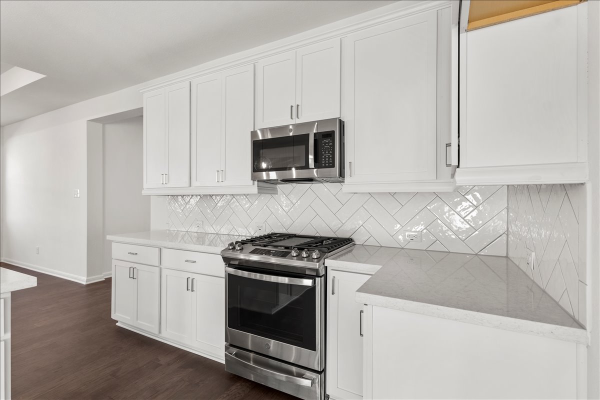 133 Grn Knl Lane Georgetown, TX 78628 - Photo 14 of 31 a kitchen with granite countertop white cabinets and stainless steel appliances