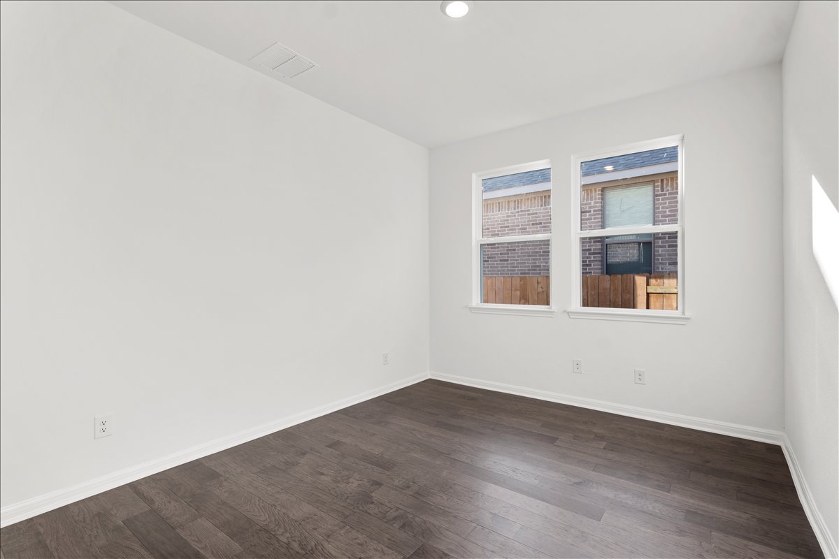 133 Grn Knl Lane Georgetown, TX 78628 - Photo 23 of 31 a view of an empty room with wooden floor and windows