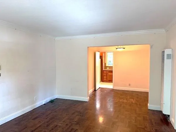 an empty room with wooden floor and a window