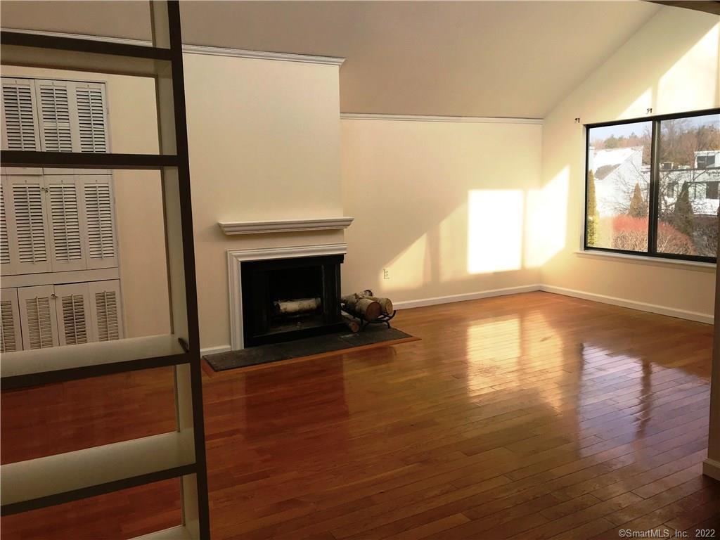 a view of empty room with fireplace and wooden floor