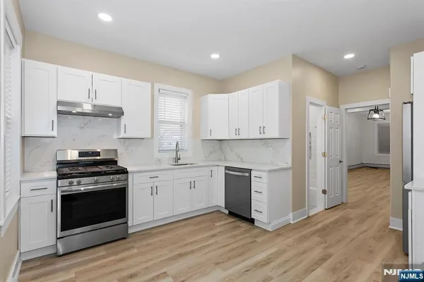 a kitchen with stainless steel appliances a sink stove and window