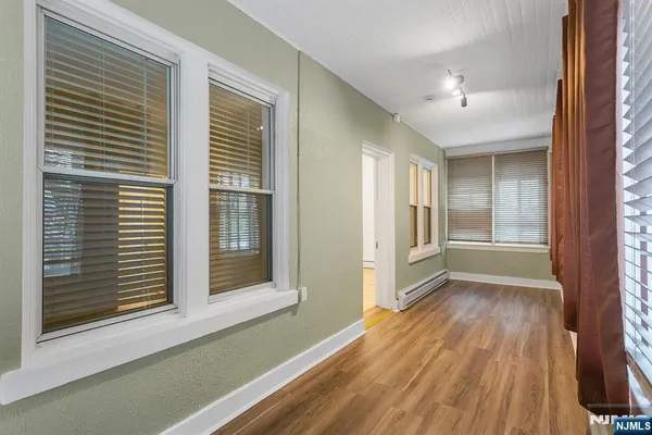 a view of a hallway with wooden floor and a window