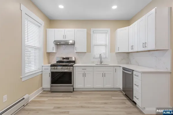 a kitchen with a stove a sink and a refrigerator