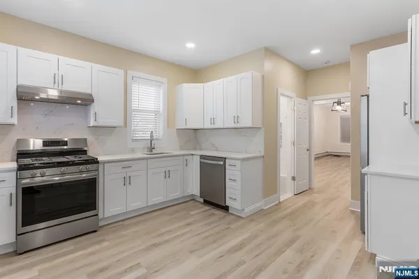 a kitchen with stainless steel appliances granite countertop a refrigerator and a stove top oven