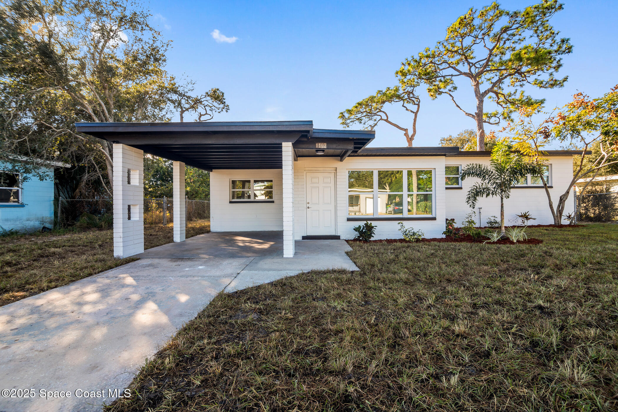 1107 Abington Street Cocoa, FL 32922 - Photo 1 of 20 a view of a house with a large tree and wooden fence