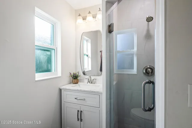 a bathroom with a shower sink and mirror