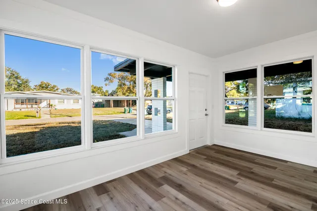 a view of an entryway with wooden floor and a floor to ceiling window