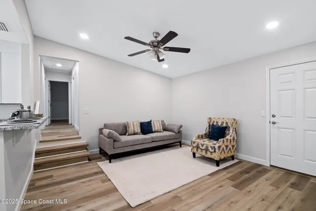 a living room with furniture and a ceiling fan