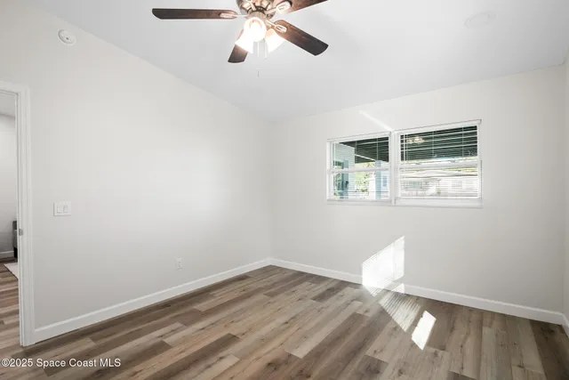 a view of a room with wooden floor and fan