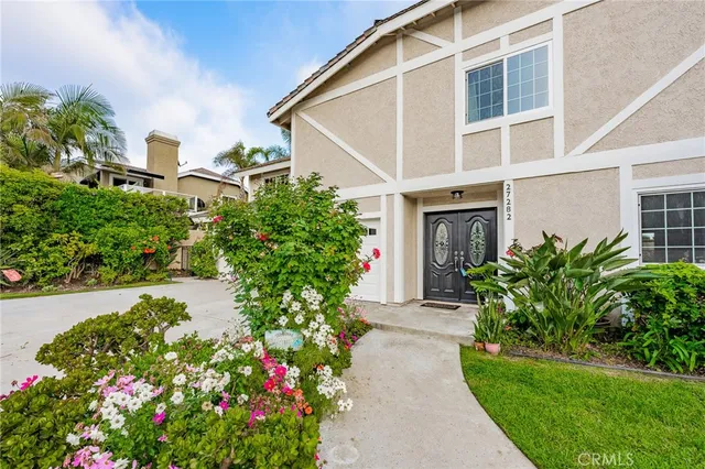 a front view of a house with a yard and flowers