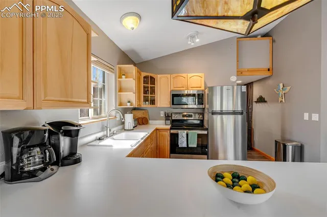 a kitchen with stainless steel appliances a refrigerator a stove a sink and a stove