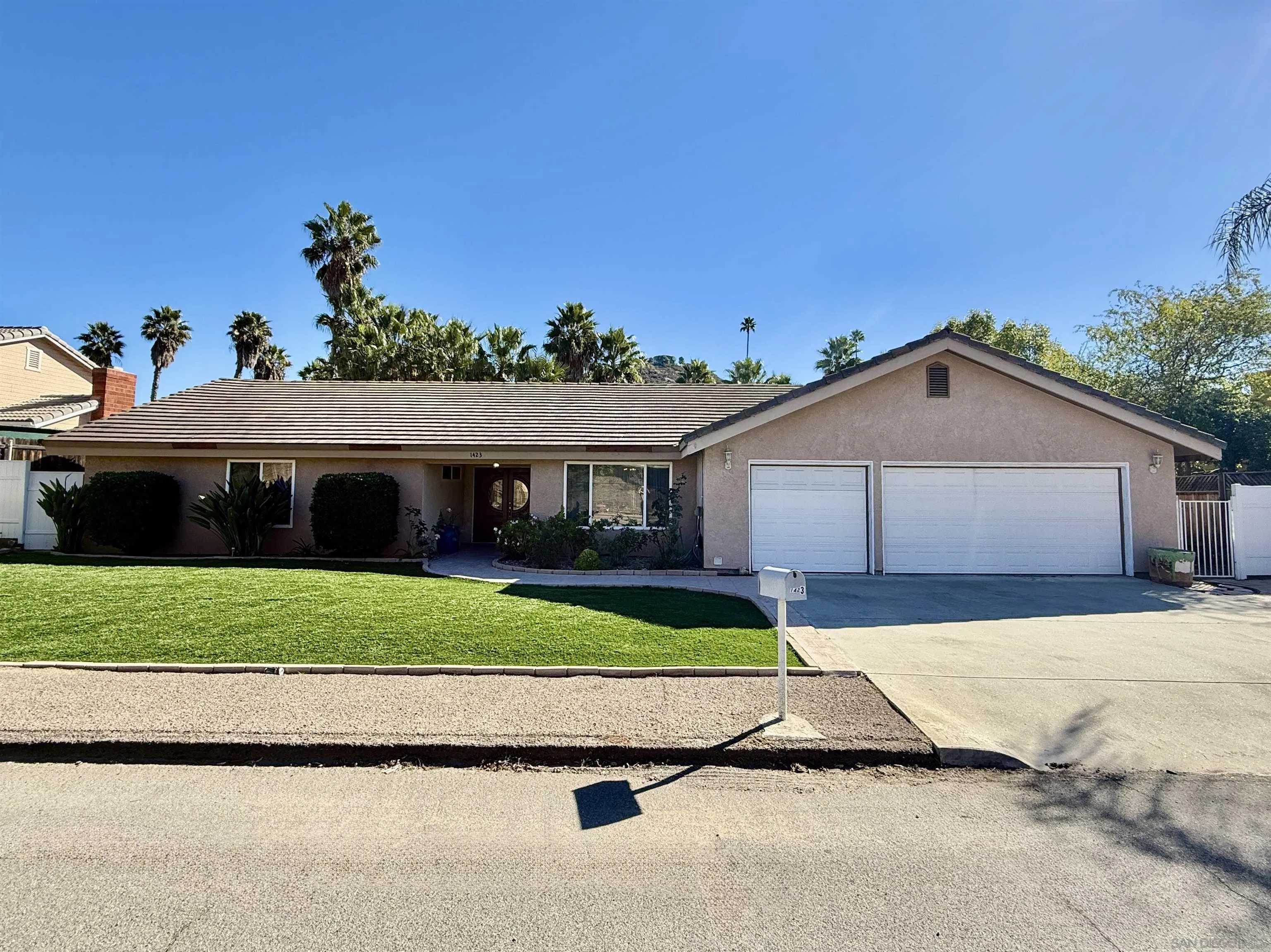 1423 Vista Grande Road El Cajon, CA 92019 - Photo 3 of 25 a front view of a house with a yard and garage